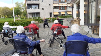 Bewoners en cliënten Mozaiek bewegen in de zon op het terras